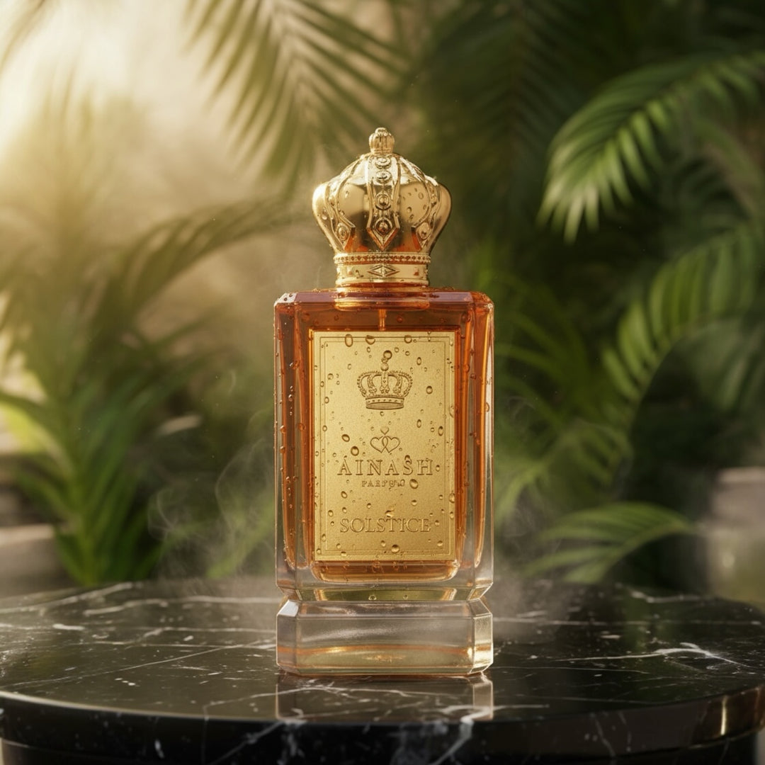 Solstice perfume by Ainash Parfums on a black marble stand surrounded by lush green leaves and golden sunlight — luxury extrait de parfum from The Hidden Realms Collection.